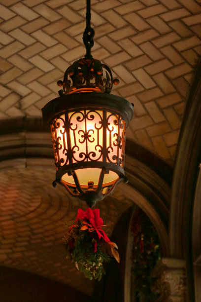 灯光昏暗的户外灯笼，装饰着红丝带和槲寄生图片下载