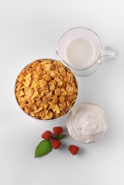 早餐是玉米片和牛奶。软木薄片。希腊酸奶和草莓。健康早餐。图片下载