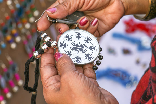 一名女性顾客的手拿着手工制作的女性项链之前购买图片下载