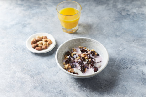 一碗加酸奶、坚果、蔓越莓和椰子的格兰诺拉麦片。一个美味和健康的概念。石头的背景。图片下载