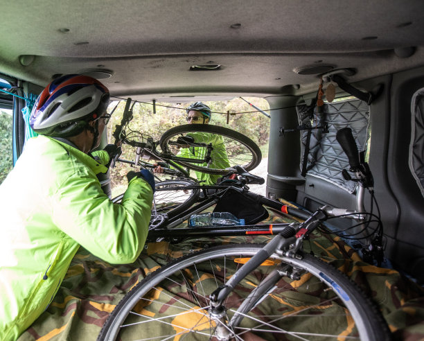 两个朋友互相帮助，把自行车放在汽车库存的照片里图片下载