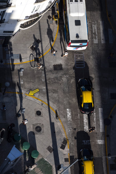 行人与自行车在午后阳光下穿过马路的阴影图片下载