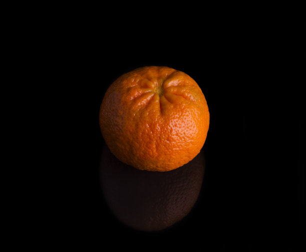 黑色背景下一个鲜亮多汁的橘子图片下载