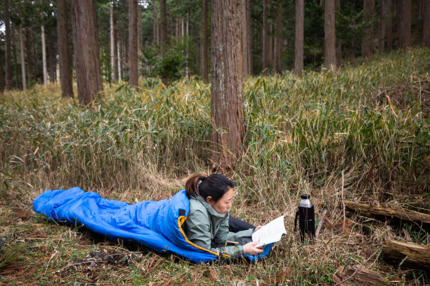 女孩喜欢在户外的睡袋里看书图片下载