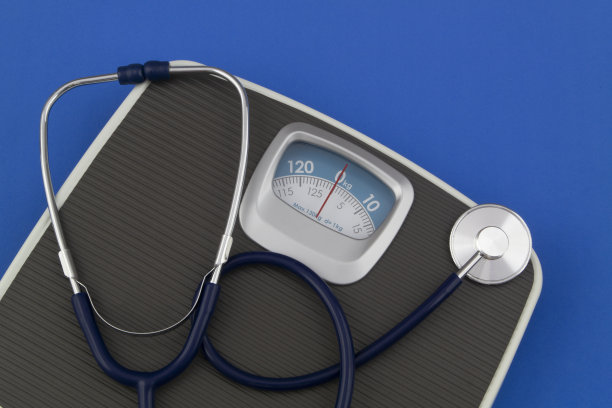 磅秤和听诊器在蓝色背景上。图片下载