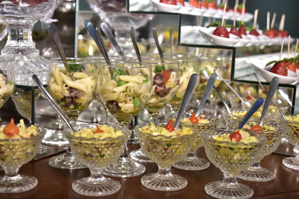 小份食物意大利面，沙拉，橄榄油，香料在玻璃杯中与照片模糊图片下载