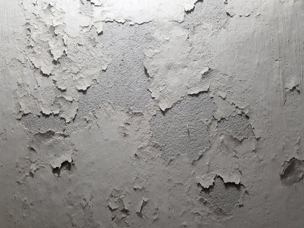 古老的背景纹理的老墙表面。旧的白色剥落石膏。灰浆大块脱落。水平方向。图片下载