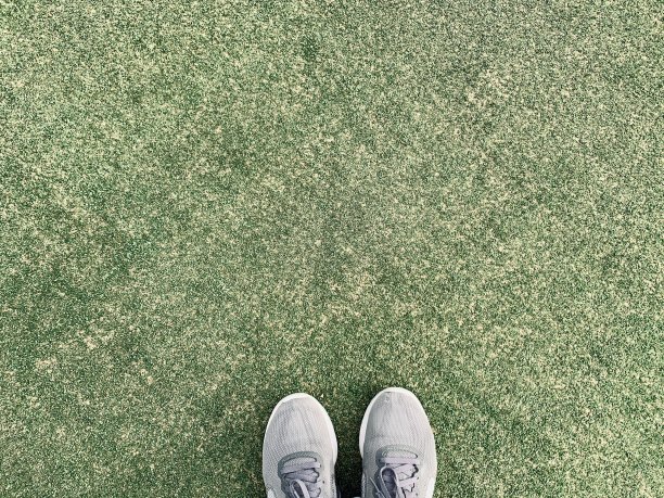 破旧的运动鞋站在绿色纹理的表面。草。网球场。本空间图片下载