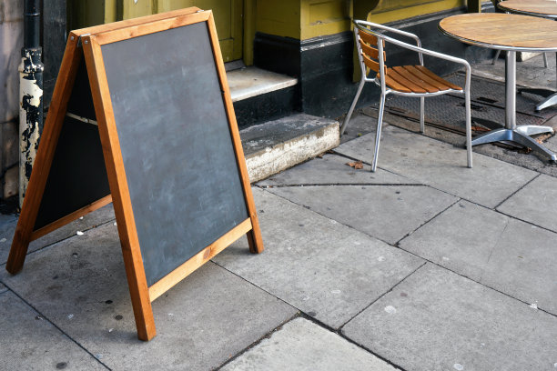 餐厅前铺着瓷砖的石头路面上，用来放菜单的空黑板桌图片下载