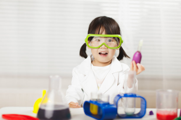 蹒跚学步的女孩在白色背景下扮演科学家的角色图片下载