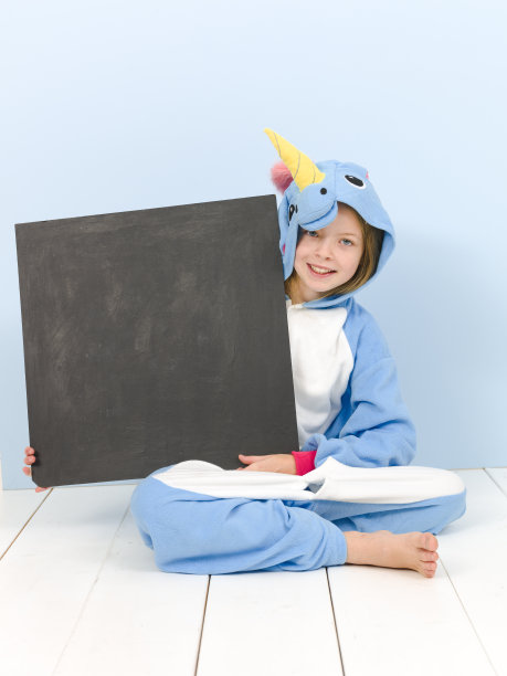 漂亮的金发女孩穿着舒适的蓝色独角兽服装和黑板在摆姿势图片下载