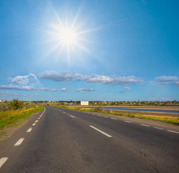 长长的柏油路下闪耀着阳光，交通出行景象图片下载
