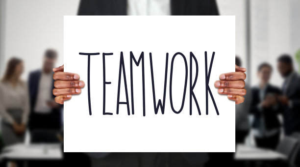 黑手握着带有团队合作文字的黑板图片下载