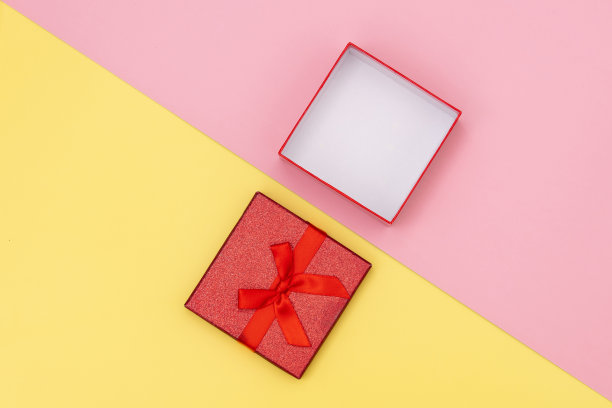 粉色和黄色背景上的小打开礼品盒。图片下载