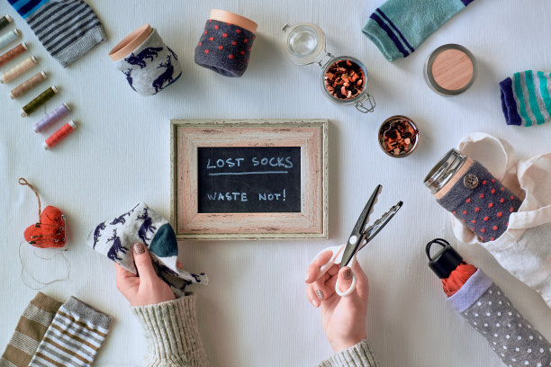“零浪费”家庭。制作竹杯和热水瓶可以用零散的袜子做袖子。孤儿不匹配的袜子升级。平铺在纺织桌布上。低影响的可持续生活方式。图片下载