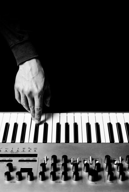 男音乐家手用键盘合成器演奏音乐，黑白相间。背景音乐图片下载