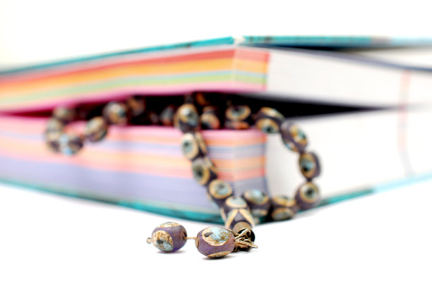 古老的念珠夹在彩色的书页间图片下载