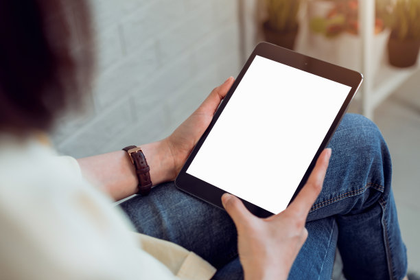女人手持平板电脑和数字笔与空白拷贝空间屏幕为您的广告。笔记本电脑放在办公室的桌子上。图片下载