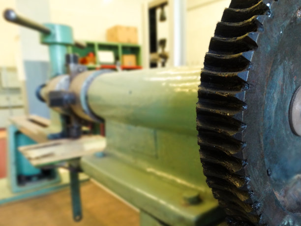 带齿轮的金属机器。工厂车间的机器和带齿轮的机械装置。浅绿色技术装置近距离与杠杆和圆盘齿图片下载