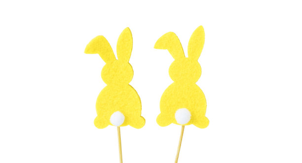 黄色复活节兔子的白色尾巴，剪影，在一根木棍上，孤立在白色的背景。复活节纪念品、装饰品。复活节的概念。本空间图片下载