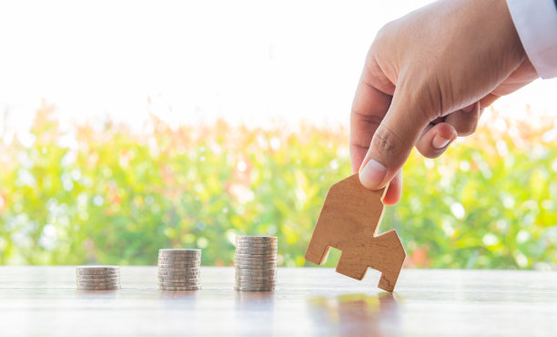 存钱硬币堆叠与日益增长的兴趣，在公共公园上的木桌概念为木制房屋模型房地产投资抵押金融真实。房地产业务部的工资收入。图片下载