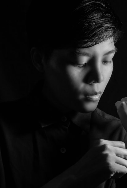 30多岁的亚洲妇女，穿着蓝色衬衫，留着短发，脸部看起来很平静。站着看相机，单人照片。黑白人像人图片下载