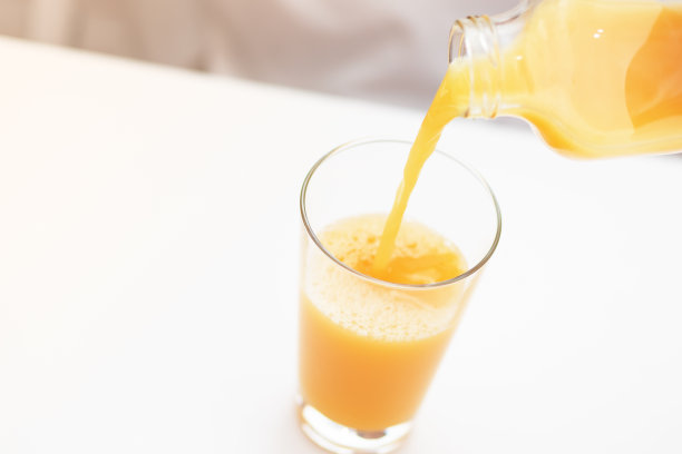 橙汁充满一个杯子。早上的早餐。图片下载