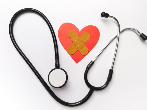 听诊器和红色的心脏形状和创可贴在白色的背景。图片下载