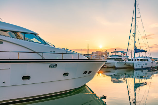 美丽清澈的日落在海港与停泊的游艇。图片下载