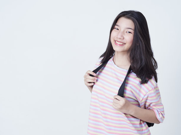 学生女孩背包里的书孤立在白色的背景。图片下载