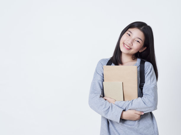 学生女孩背包里的书孤立在白色的背景。图片下载