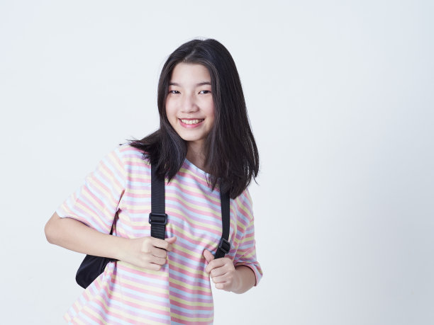 学生女孩背包里的书孤立在白色的背景。图片下载