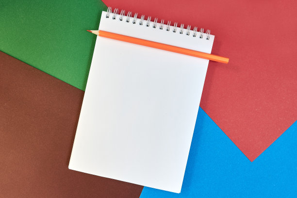 学习用品，打开笔记本，铅笔，白纸上的彩色硬纸板背景与文字的地方。回到学校。教育和办学理念。平的。本空间图片下载