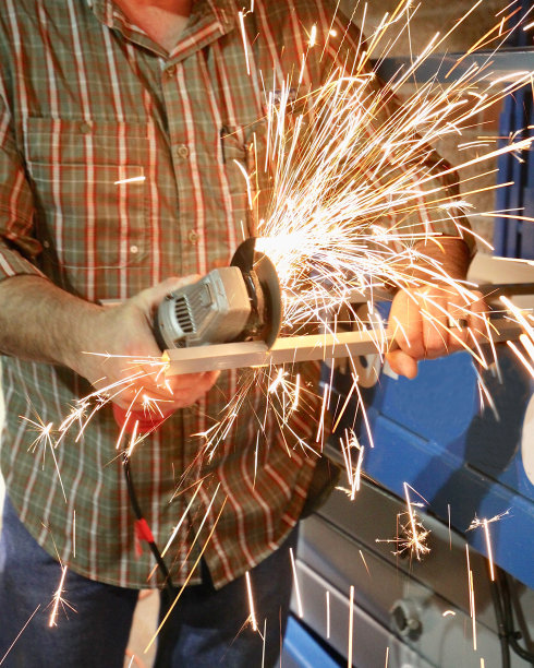 当一个工人切割金属时，火花飞溅图片下载