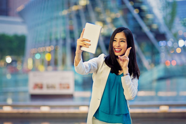 一名年轻的日本女子正在用平板电脑自拍/视频通话图片下载