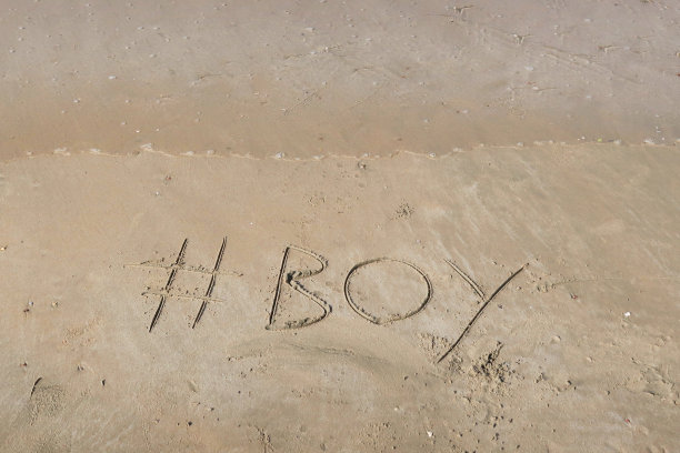 图片的标签标签写在阳光明媚的海滩上，男孩的单词写在海边的沙子上，帕洛伦海滩，印度果阿，概念社交媒体照片的手写在金色的沙子与现代标签前缀图片下载
