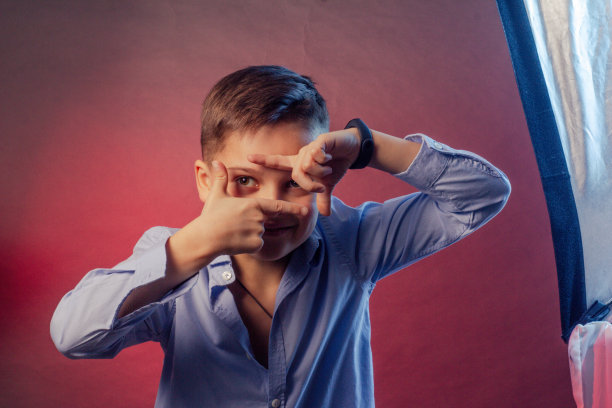 那男孩穿着一件蓝色衬衫，背景是紫色和栗色。图片下载