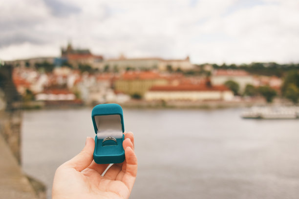 老城广场前的女人拿着一个装有订婚戒指的蓝色盒子。布拉格，捷克共和国。胶片效果，作者对照片的处理图片下载