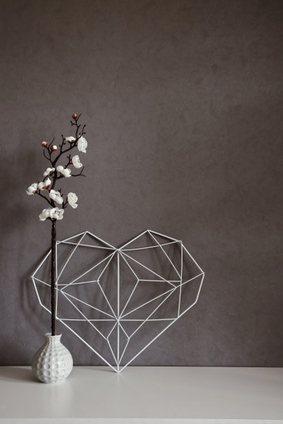 公寓内时尚的静物生活。室内混凝土墙的背景上有优雅的镂空心。极简主义。概念象征着爱情和情人节。家居装饰图片下载