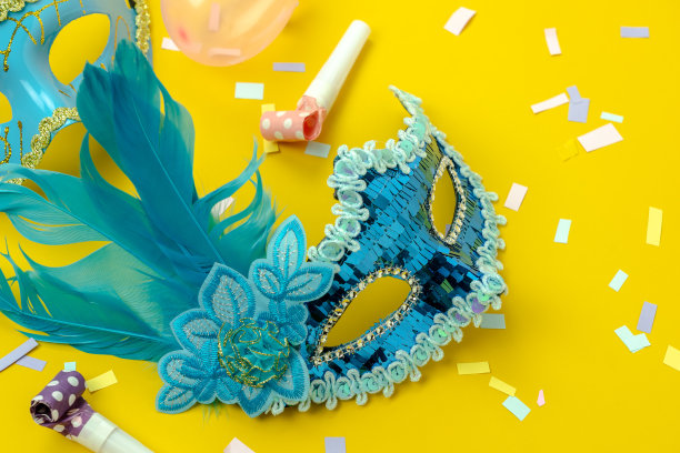 桌面俯瞰航拍图像的美丽多彩的狂欢节季节或照片亭prop Mardi Gras背景。平铺物体蓝色面具与装饰在黄色墙纸。为文本模拟提供空闲空间图片下载