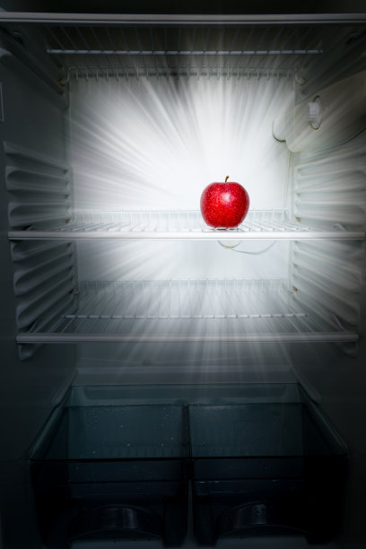概念创意照片在黑暗中发光的新鲜红苹果在一个开放的空冰箱。减肥饮食概念。图片下载