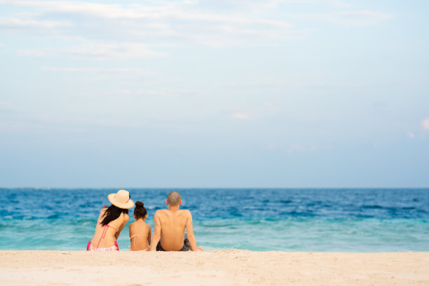 爸爸、妈妈和女儿坐在海滩上图片下载