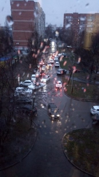 晚上,《暮光之城》。窗外的景色透过雨滴进入满是红灯的汽车的庭院。图片下载