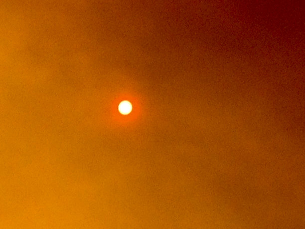 橙色的太阳在烟雾弥漫的天空图片下载