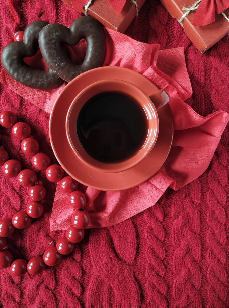 情人节当天，在红色针织毛衣上放上一杯咖啡和心形饼干图片下载