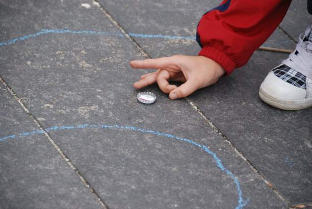 孩子们在街上玩瓶盖比赛图片下载