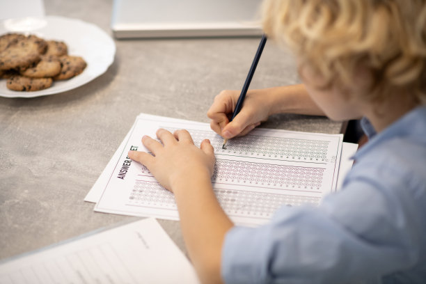 一个金发男孩写测验的近照图片下载
