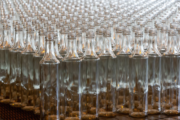 玻璃器皿。玻璃行业。许多玻璃瓶在工厂的传送带上。图片下载
