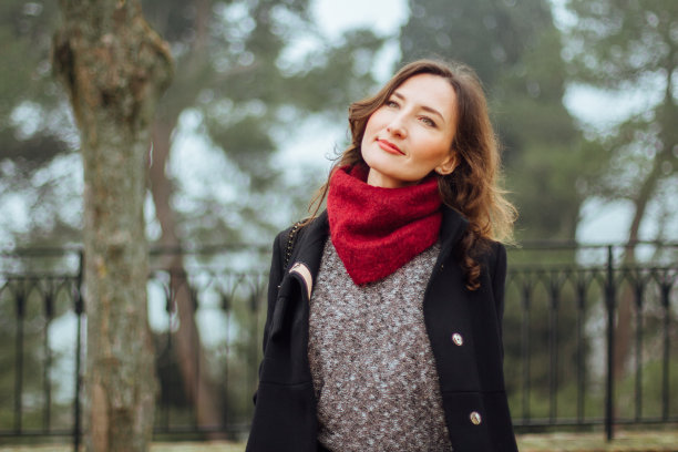 年轻浪漫的黑发女人在绿色朦胧的背景图片下载