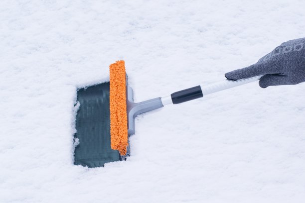 一个女人正在清理车窗里的雪图片下载